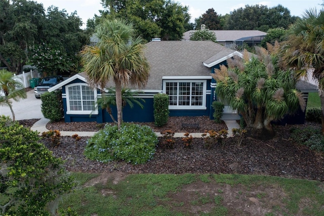 view of front facade featuring fence and roof with shingles