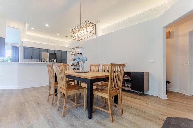 dining room featuring light wood-type flooring, baseboards, and recessed lighting