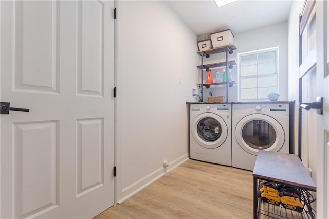 laundry room with baseboards, laundry area, washer and clothes dryer, and light wood-style floors