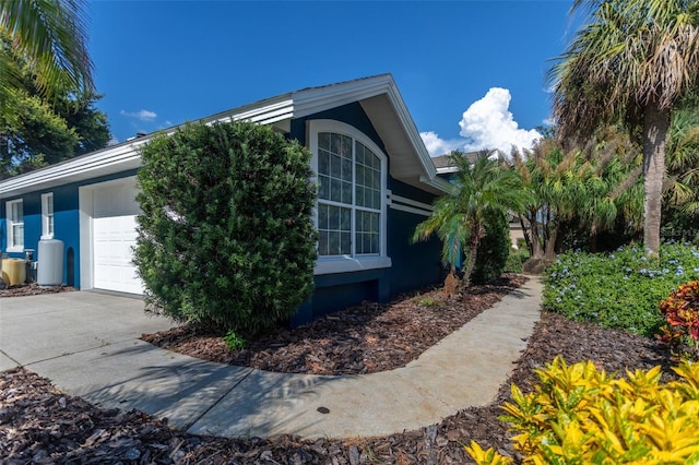 view of home's exterior with a garage, driveway, and stucco siding