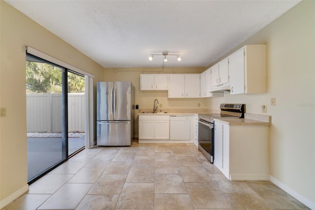 kitchen featuring white cabinets, under cabinet range hood, appliances with stainless steel finishes, and light countertops