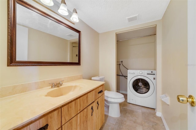 bathroom with washer / dryer, visible vents, toilet, a textured ceiling, and vanity