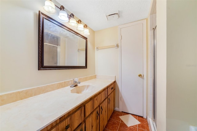 full bath featuring a stall shower, visible vents, tile patterned floors, a textured ceiling, and vanity