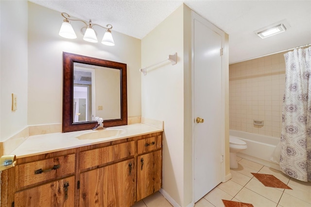 bathroom featuring toilet, vanity, a textured ceiling, and tile patterned floors