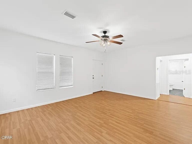 spare room featuring visible vents, light wood-style flooring, and baseboards