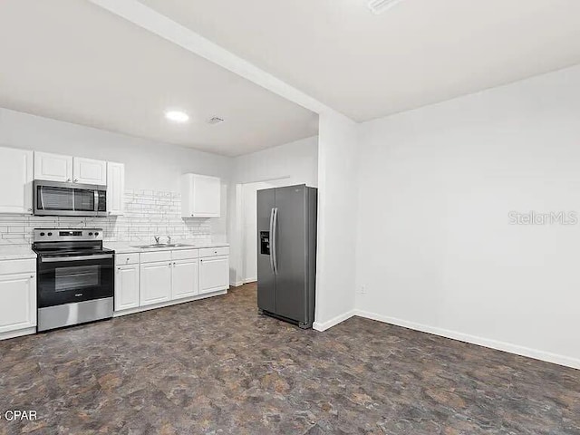 kitchen with stainless steel appliances, light countertops, white cabinetry, and decorative backsplash