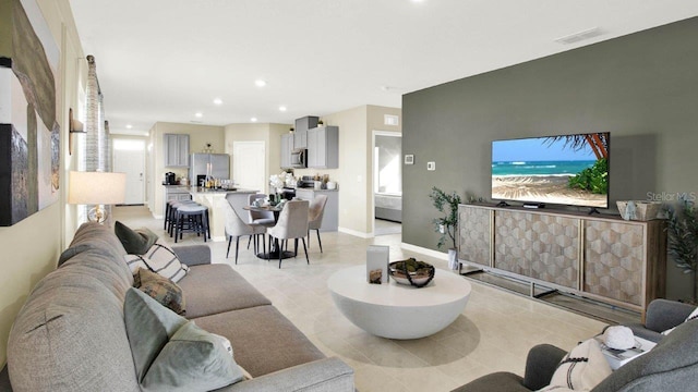 living room with baseboards, light tile patterned flooring, visible vents, and recessed lighting