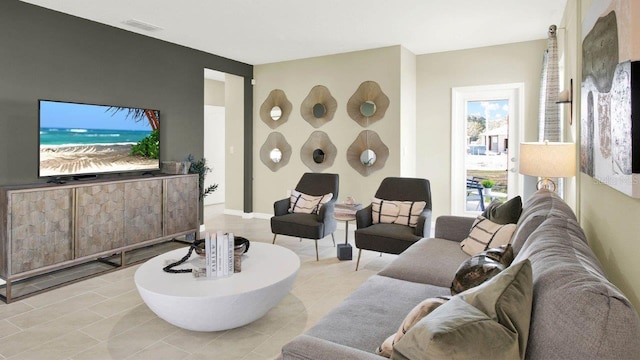 living area featuring visible vents and light tile patterned flooring