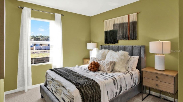 bedroom with light carpet and baseboards