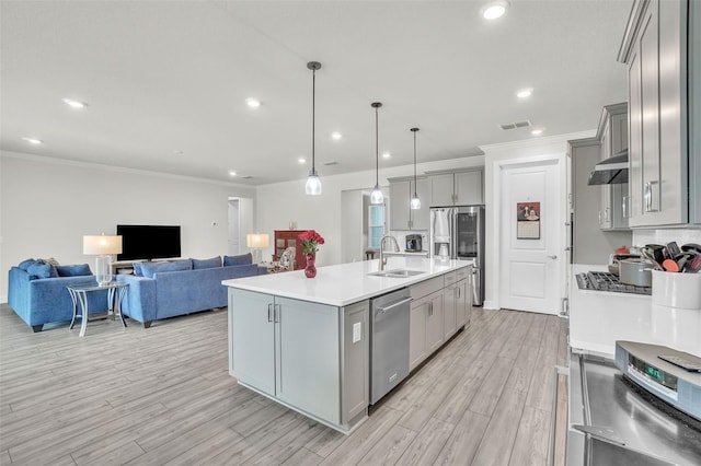 kitchen featuring a sink, stainless steel appliances, open floor plan, and gray cabinets