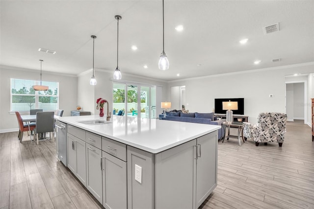 kitchen featuring visible vents, gray cabinets, light countertops, light wood-type flooring, and a sink