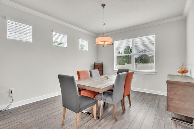 dining area with crown molding, light wood finished floors, and baseboards