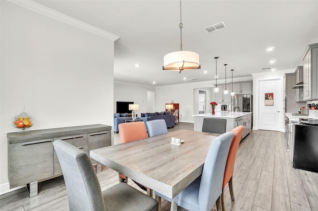 dining space featuring light wood finished floors, visible vents, baseboards, ornamental molding, and recessed lighting