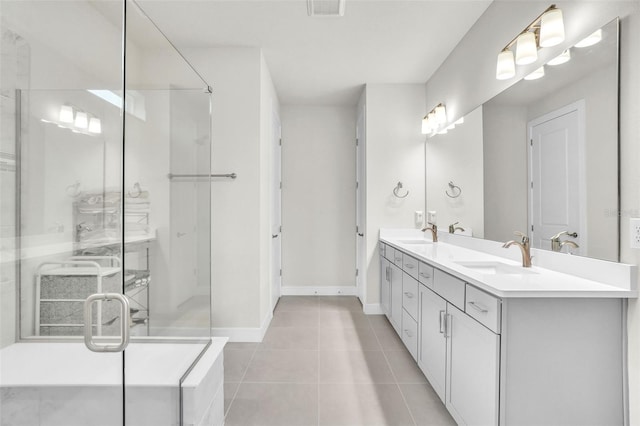 bathroom with double vanity, a stall shower, tile patterned flooring, and a sink