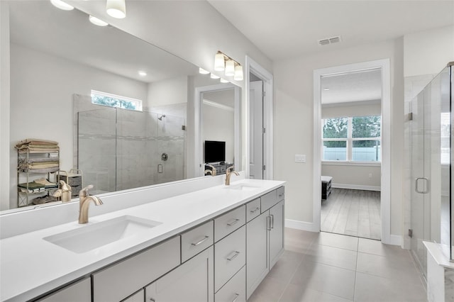 ensuite bathroom with double vanity, ensuite bath, a sink, and visible vents