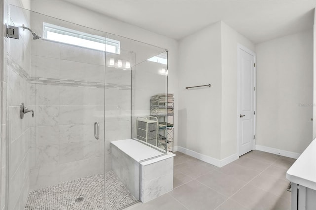 bathroom featuring a shower stall, baseboards, and tile patterned flooring