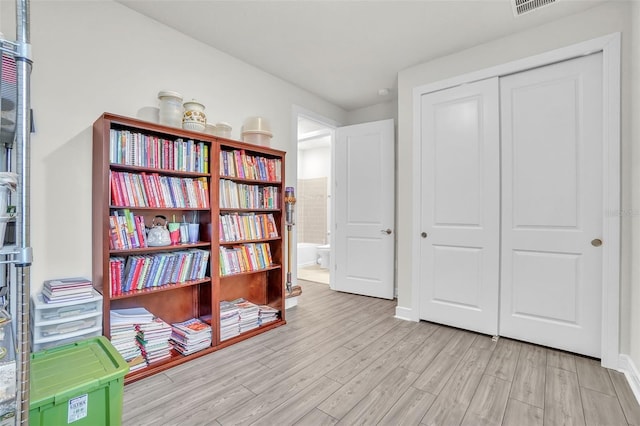 sitting room with visible vents, baseboards, and wood finished floors