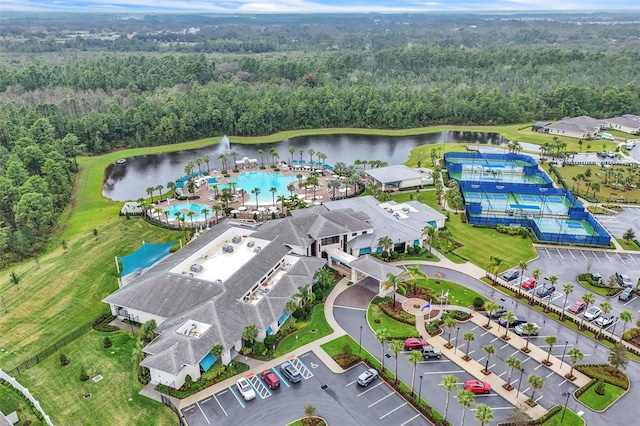 drone / aerial view with a forest view and a water view