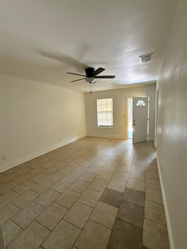 foyer featuring visible vents, a ceiling fan, light tile patterned flooring, a textured ceiling, and baseboards