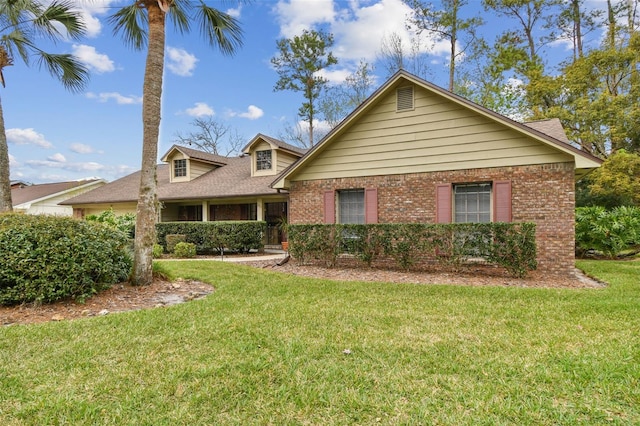 view of front of house with a front yard and brick siding