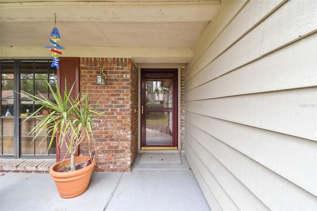 view of exterior entry with brick siding