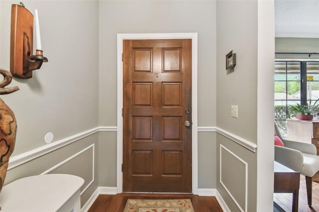 entrance foyer with dark wood-style floors and a textured ceiling