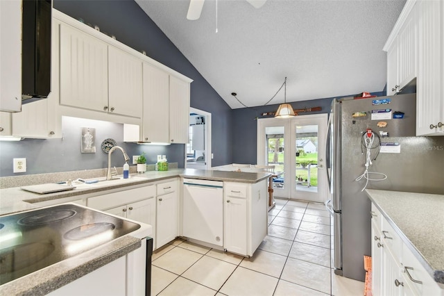 kitchen featuring dishwasher, a peninsula, decorative light fixtures, and white cabinets