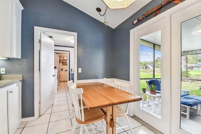 dining room featuring lofted ceiling, baseboards, visible vents, and light tile patterned flooring