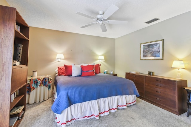 bedroom with light carpet, ceiling fan, a textured ceiling, and visible vents