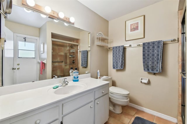 bathroom featuring toilet, a shower stall, vanity, baseboards, and tile patterned floors