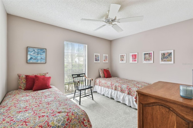 bedroom featuring a textured ceiling, a ceiling fan, and light colored carpet