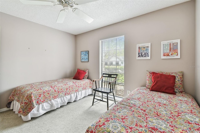 carpeted bedroom featuring a textured ceiling and a ceiling fan