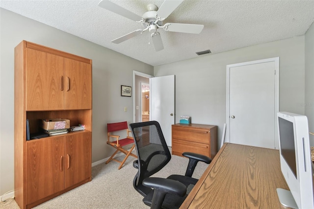 office space featuring ceiling fan, a textured ceiling, light carpet, visible vents, and baseboards