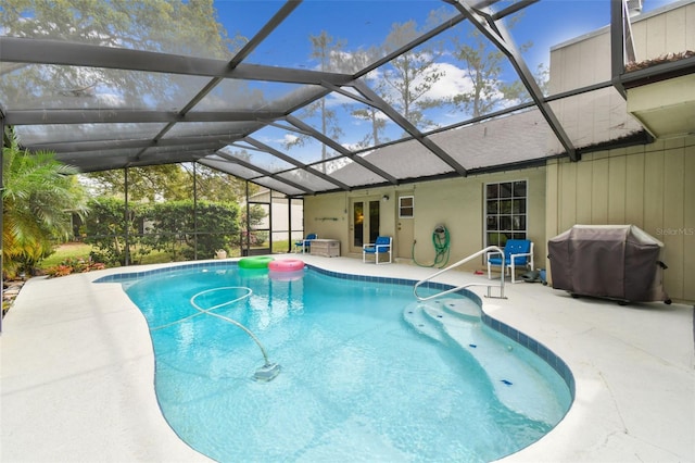 pool featuring a lanai, a patio area, and a grill