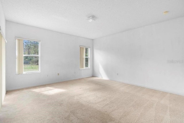 carpeted empty room with a textured ceiling