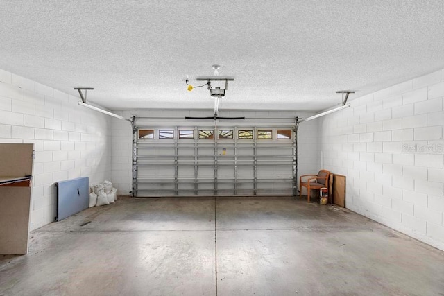 garage with concrete block wall and a garage door opener