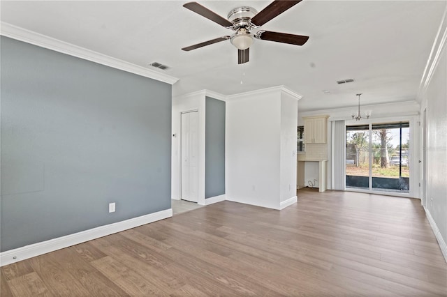 spare room with ornamental molding, visible vents, and light wood-style floors