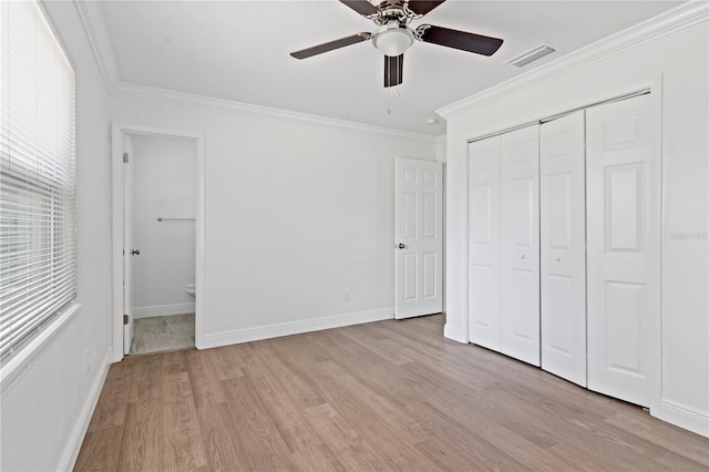 unfurnished bedroom with light wood-style flooring, a closet, visible vents, and crown molding