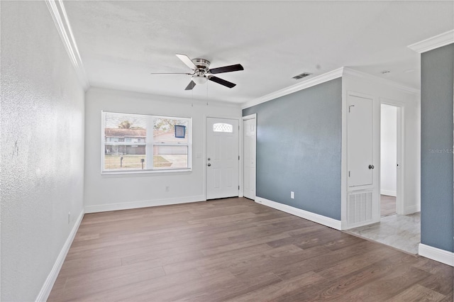 entryway with baseboards, ornamental molding, visible vents, and light wood-style floors