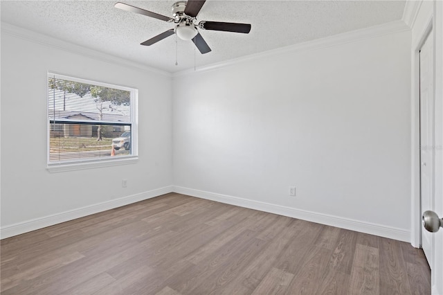 spare room with ornamental molding, light wood-type flooring, a textured ceiling, and baseboards