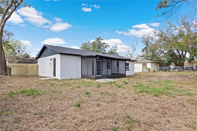 back of house with a fenced backyard and a gate