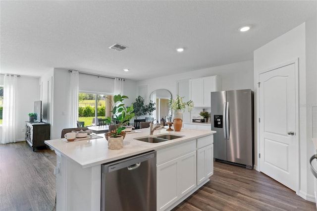 kitchen with an island with sink, white cabinetry, stainless steel appliances, and light countertops