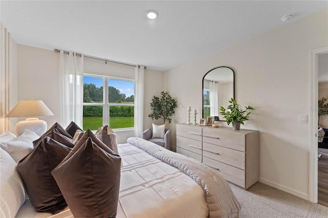 bedroom featuring light carpet and baseboards