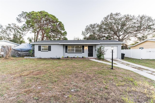 single story home with an attached garage, fence, concrete driveway, and a front yard