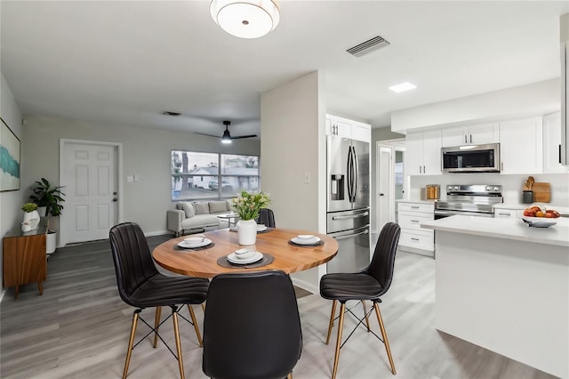 dining room featuring light wood-type flooring, visible vents, and ceiling fan