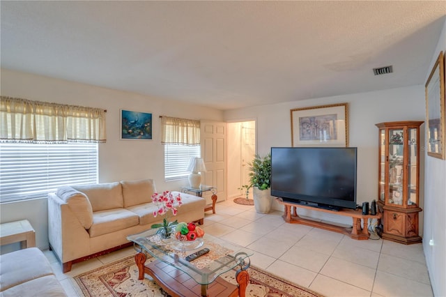 living area with visible vents and light tile patterned floors