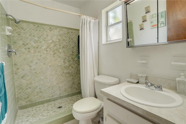 full bath featuring a stall shower, vanity, and toilet