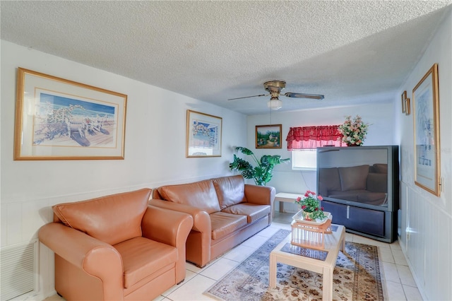 living area with light tile patterned floors, ceiling fan, a textured ceiling, and visible vents