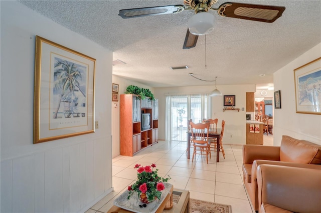 living room with visible vents, ceiling fan, a textured ceiling, and light tile patterned floors