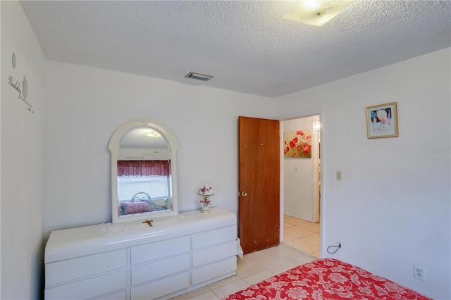 bedroom featuring visible vents, a textured ceiling, and light tile patterned flooring